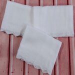 white muslin squares adorned with hand made lace trims and hand embroidered