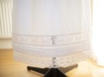 white cotton underskirt adorned with lace trims and pin tucks