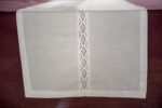 white cotton table runner adorned with a strip of lace across the middle of it
