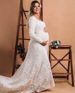 beautiful pregnant bride wearing a lovely bespoke handmade long sleeve lace wedding dress with a mid-sized train