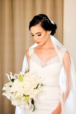beautiful bride wearing a fully bespoke handmade lace veil over her gorgeous handmade lace wedding dress
