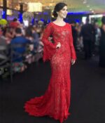 beautiful tall woman in a catwalk wearing a gorgeous bespoke handmade red bridesmaid dress with long sleeves