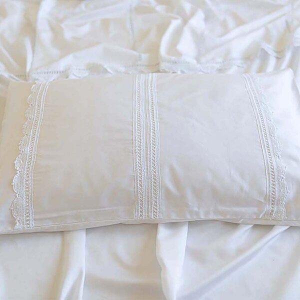 bespoke white cotton pillowcases embellished with three strips of handmade lace trims across them